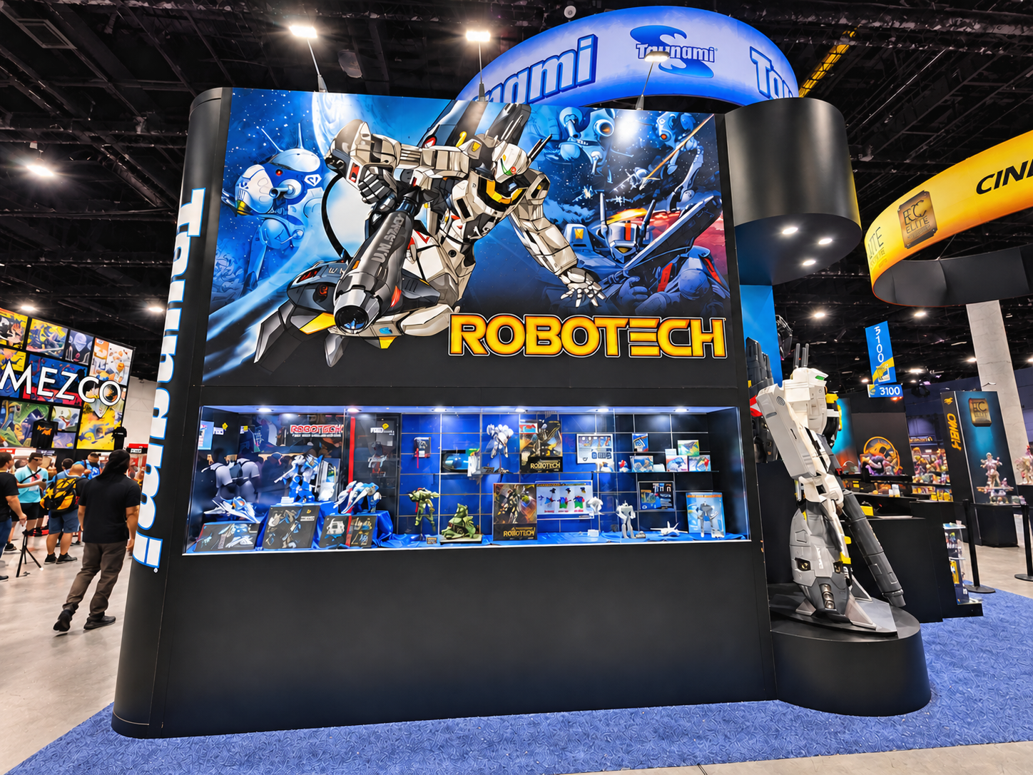 Black booth wall carrying a Robotech graphic above a display case